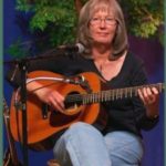 Image of Kathy Barwick playing guitar.