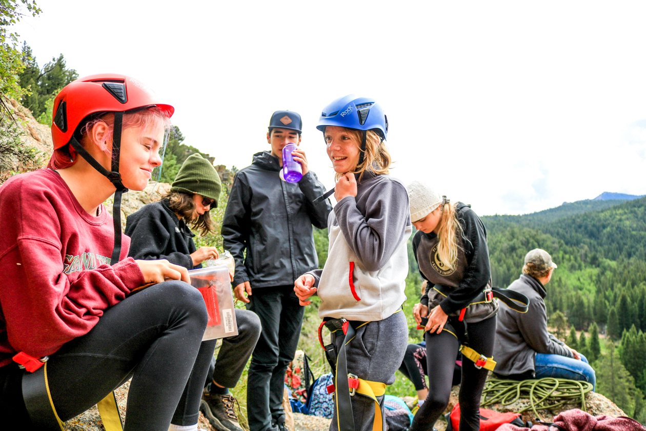 Wilderness campers repelling down a cliff face.